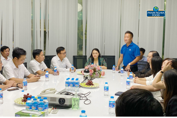 Bà Nguyễn Thị Thu Hà (Áo xanh) lắng nghe những chia sẻ từ đại diện công ty PHAM NGHIA FOOD